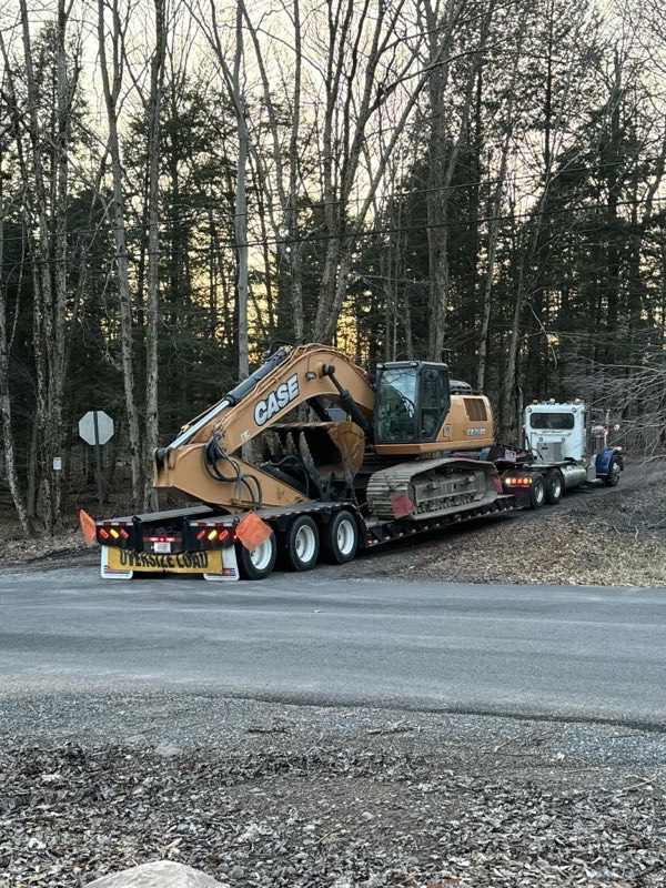 Excavation contractor hauling equipment to project site in Seneca County
