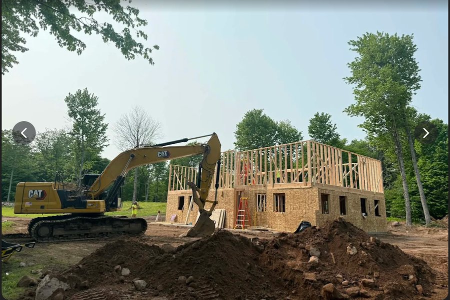Excavator preparing building pad on a framing site
